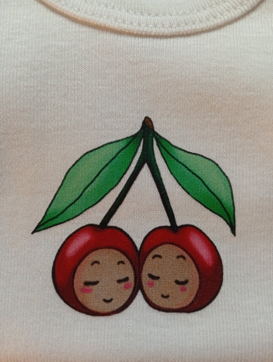 Cute cherry baby logo with two smiling cherry faces and green leaves on white fabric