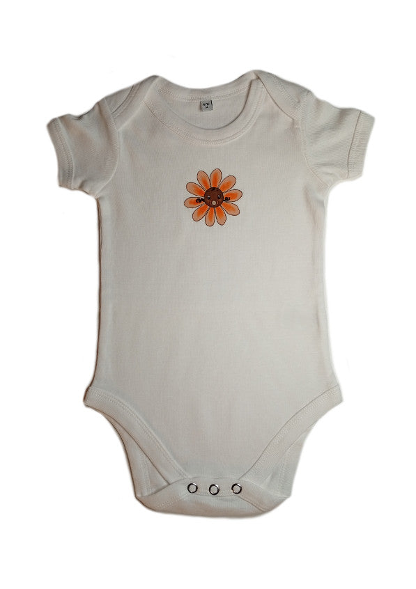 White baby onesie with orange flower graphic and snap buttons on a white background