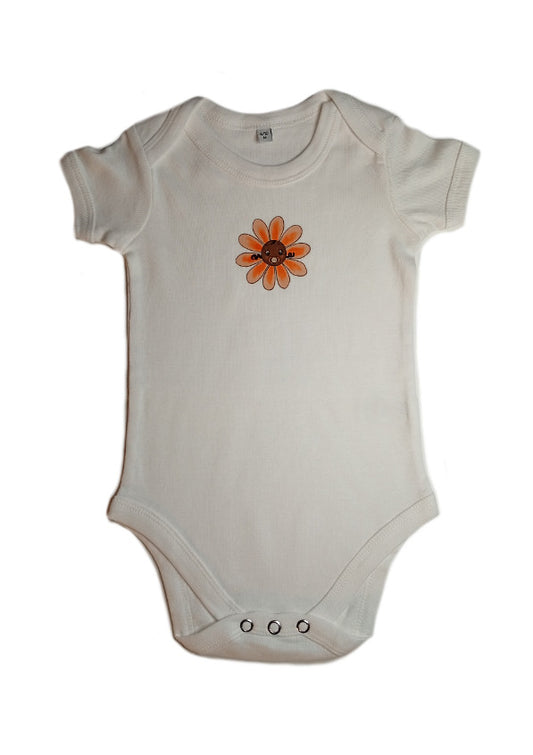 White baby onesie with orange flower graphic and snap buttons on a white background