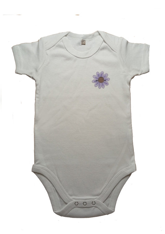 White baby onesie with short sleeves and a small purple flower graphic on the chest