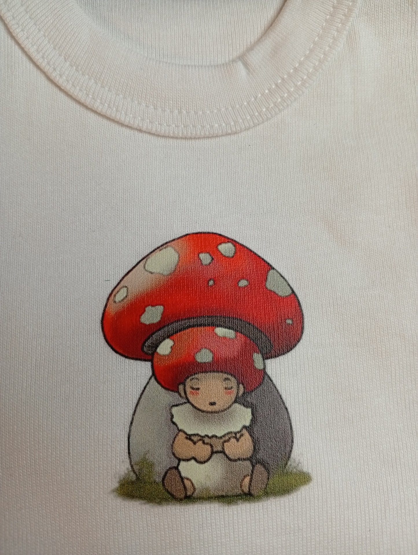 Cute mushroom baby cartoon under red spotted mushroom on white fabric