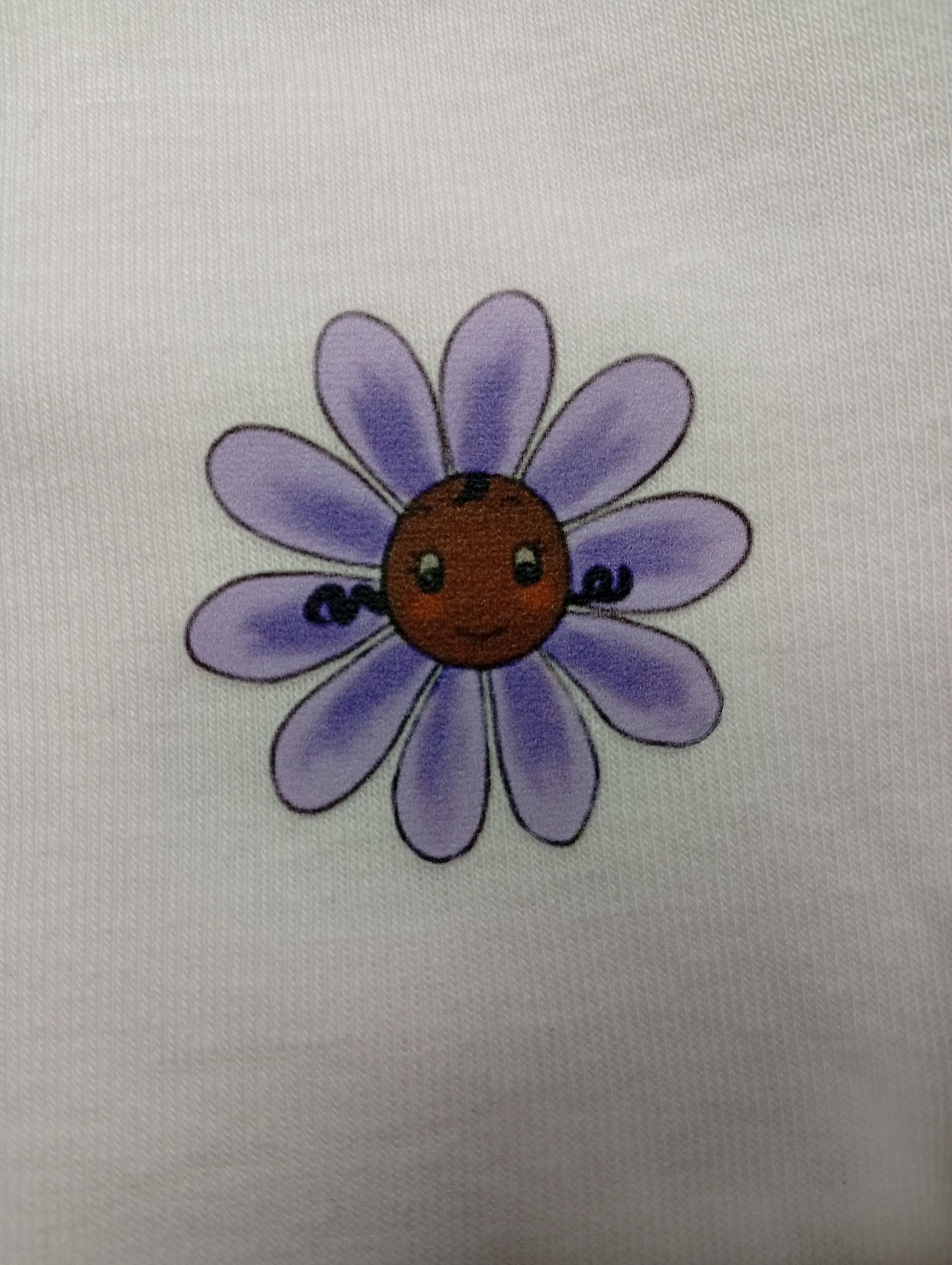 Cute purple daisy flower with a smiling face on white fabric background