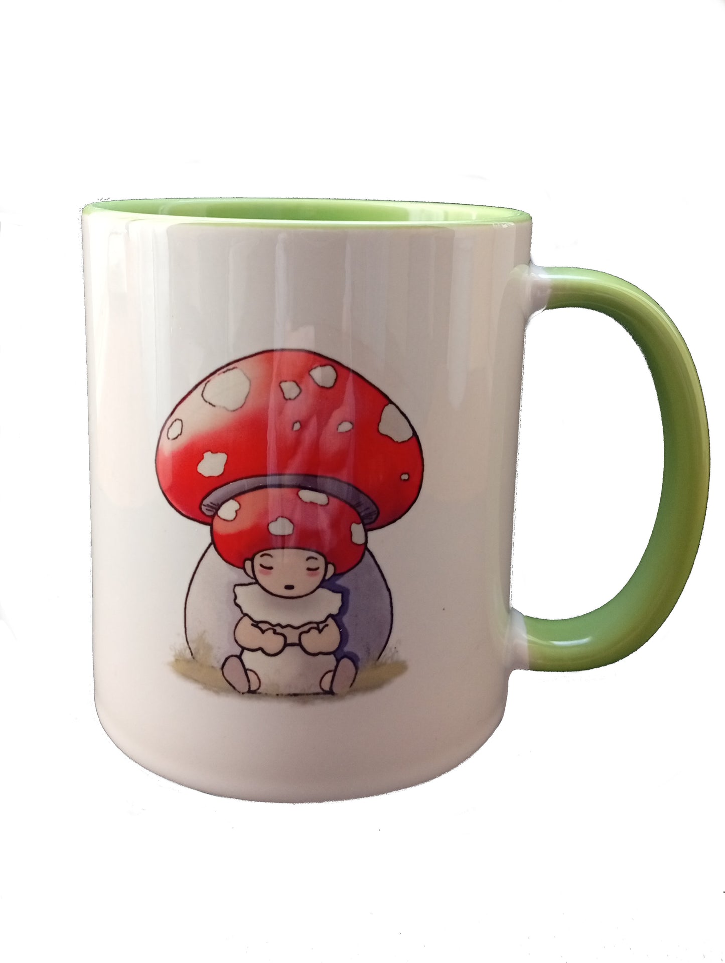 White mug with green handle featuring cute baby under red spotted mushroom illustration